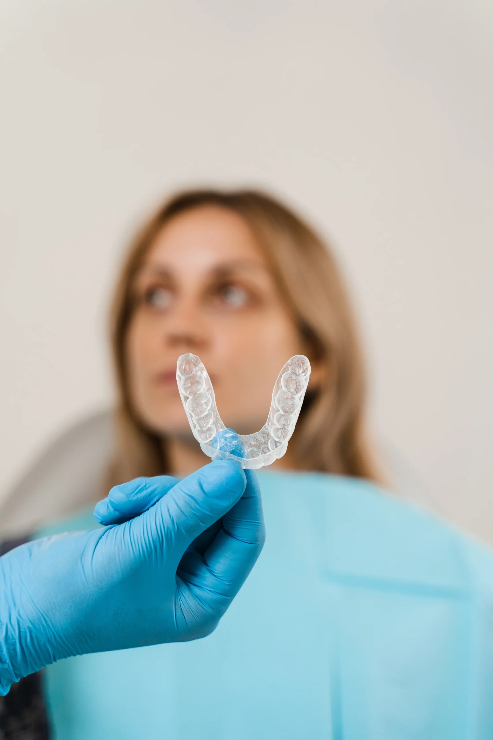 Alineador transparente de ortodoncia invisible sostenido por una odontóloga