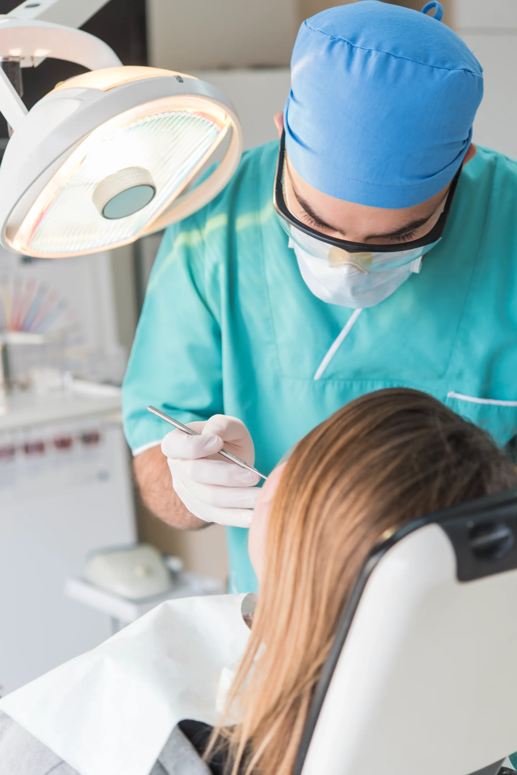 Odontólogo de Clínica Dental Agudo Rosa revisando la boca de una paciente